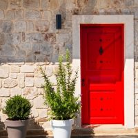 Red,Door,And,Potted,Plants,At,The,Entrance.,Facade,Of