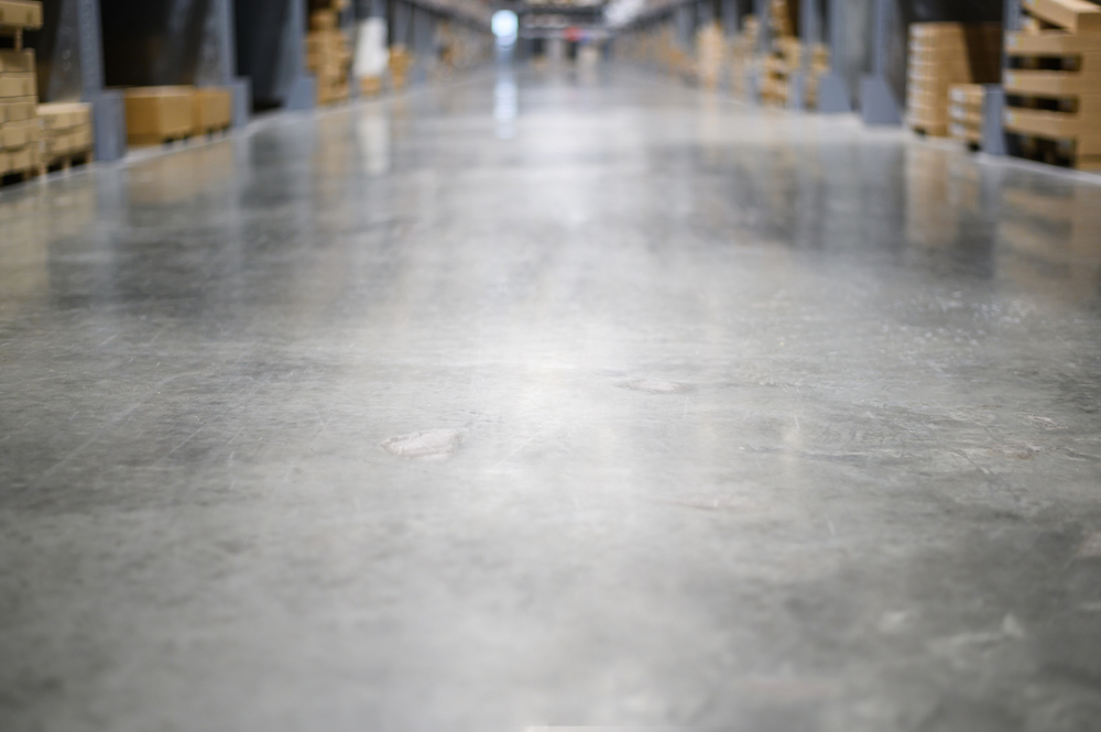 Low,Angle,View,Of,Concrete,Floor,In,Large,Warehouse,Store.